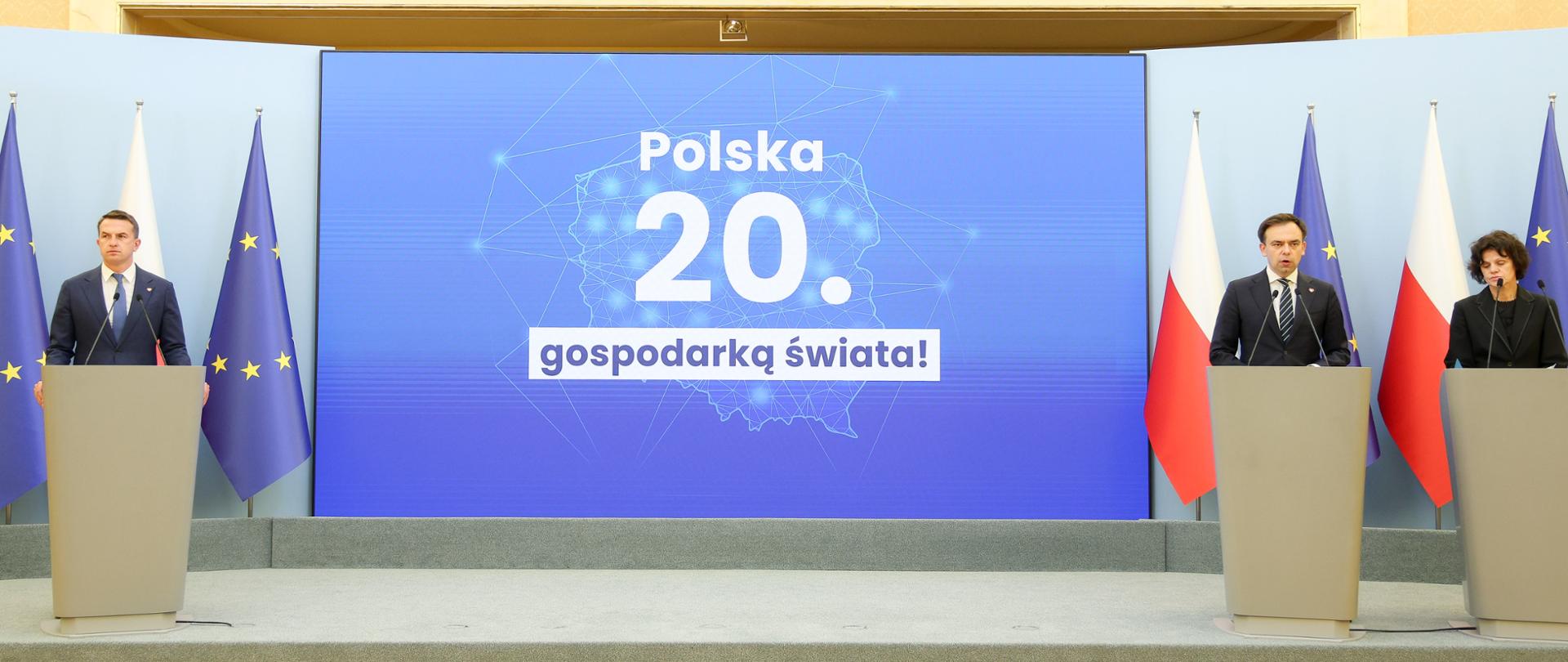Minister Finansów i Gospodarki Andrzej Domański, Rzecznik rządu Minister Adam Szłapka i Podsekretarz Stanu w Ministerstwie Finansów Hanna Majszczyk podczas konferencji prasowej. W tle ekran 